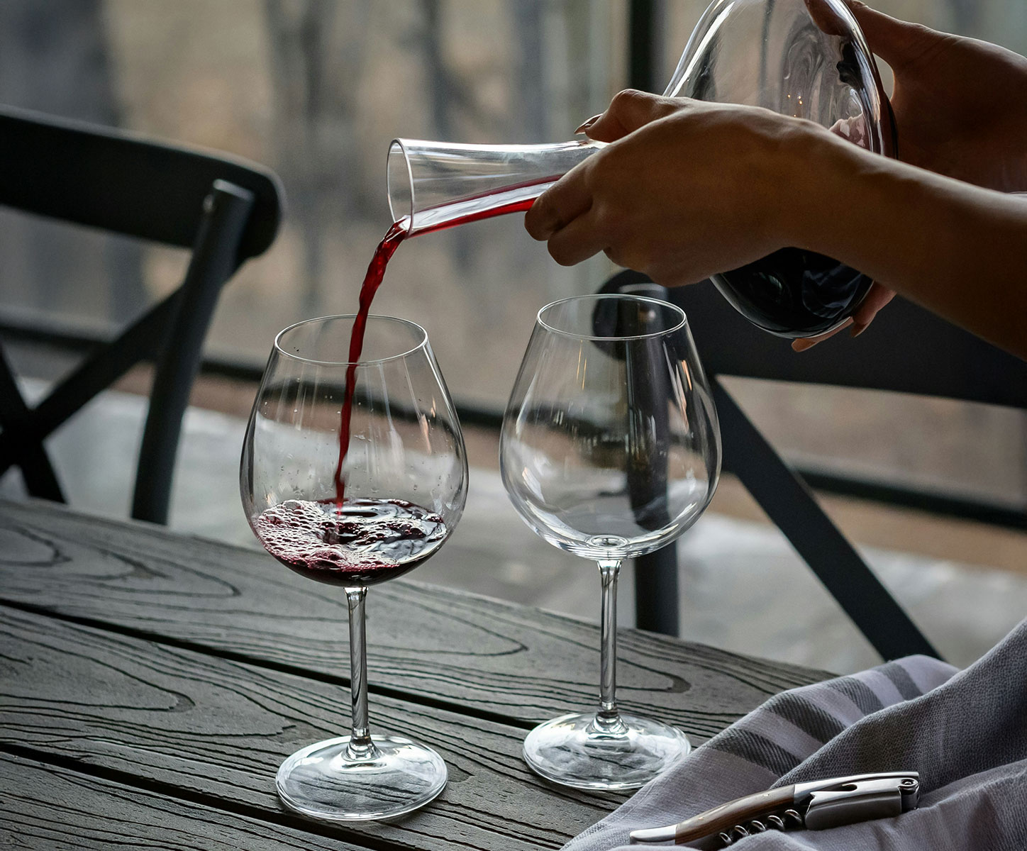 Pouring red wine out of a glass flask